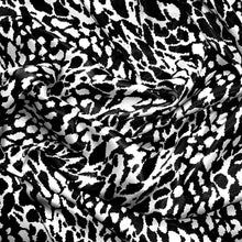 Load image into Gallery viewer, Black and white satin fabric displayed in a swirl.