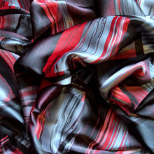 Load image into Gallery viewer, Red, black and gray satin fabric in an abstract modern print displayed in a swirl.