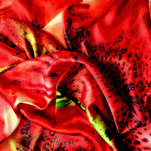 Load image into Gallery viewer, An above view looking down at swirled satin material in an orange, black and green leopard print.