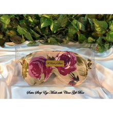 Load image into Gallery viewer, A plum roses and green leaves floral print satin sleep mask. The sleep mask is in a clear acrylic gift box. It is placed on top of white satin with various green plants in the background.