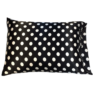 A travel pillow with a black pillowcase with one inch diameter white dots on it. The pillow measures 12" x 16".