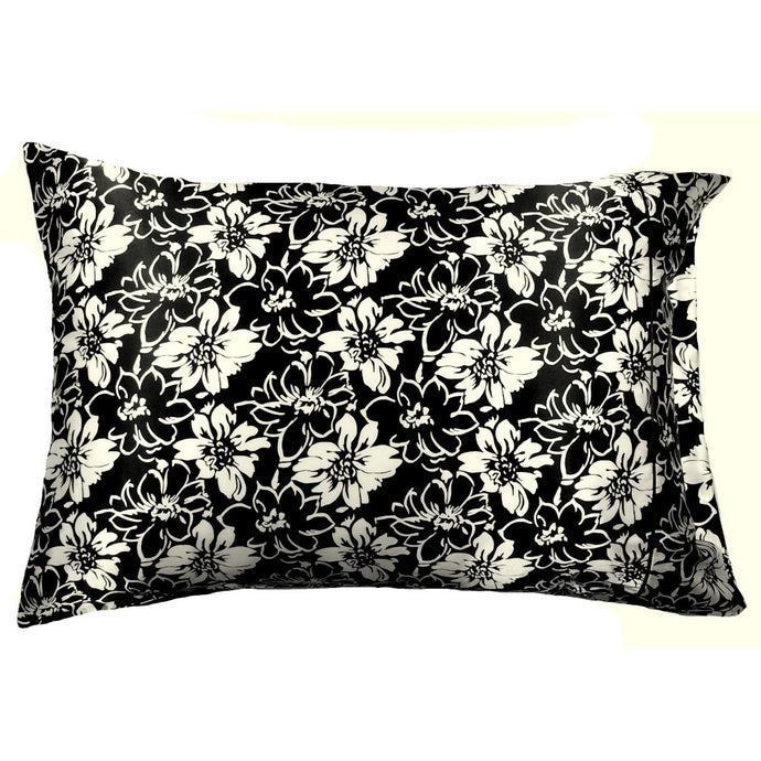 A black satin pillowcase with white flowers and black flowers etched in white.