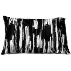 A travel pillow with a satin pillowcase with splashes of black and white vertical lines. The pillow measures 12" x 16".