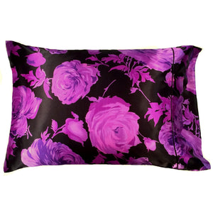 A bedroom pillow with a black satin pillowcase that has purple roses on it. The pillow measures 12" x 16".