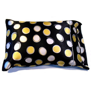 A pillow with a black pillowcase cover that has large white and yellow polka dots. The pillow measures 12" x 16".