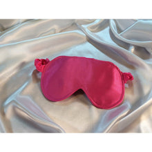 Load image into Gallery viewer, Bubblegum pink eye sleep mask lying on top of white satin sheets.
