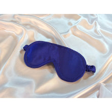 Load image into Gallery viewer, A royal blue satin sleep eye mask is lying on top of white satin sheets.