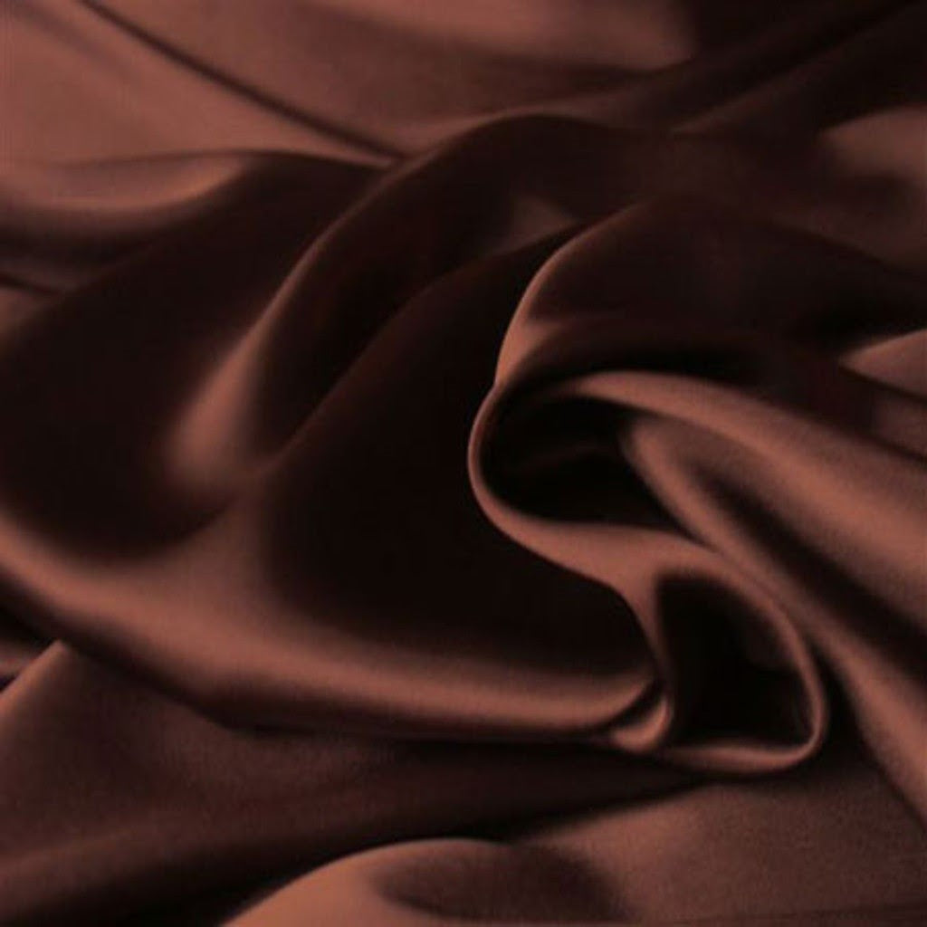 a view from above looking down at brown satin material. The material is in a swirl pattern.