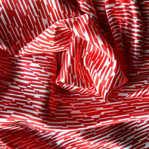 red and white satin pillowcase swirled to show the pattern.