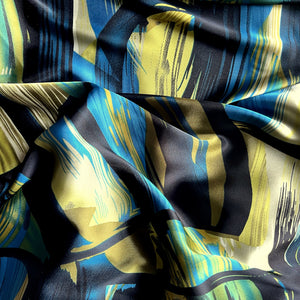 Black, turquoise bue, green and gold abstract print displayed in a swirl.