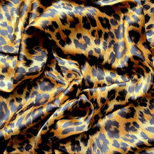 Load image into Gallery viewer, A swirled piece of satin material in a beautiful African leopard animal print in gold and black. 
