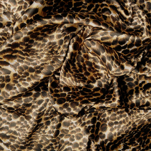 A wide view of a beautiful leopard print in gold, brown and black. The satin material is swirled.