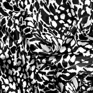 Black and white satin fabric displayed in a swirl.