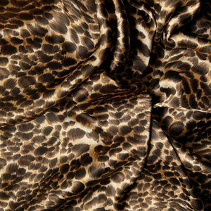 A beautiful leopard print in gold, brown and black. The satin material is swirled.