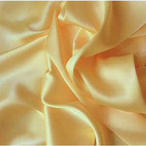 A view from above looking at yellow satin material in a swirled pattern.