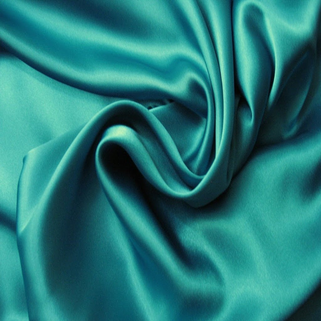 satin material in solid teal green. The material is swirled.