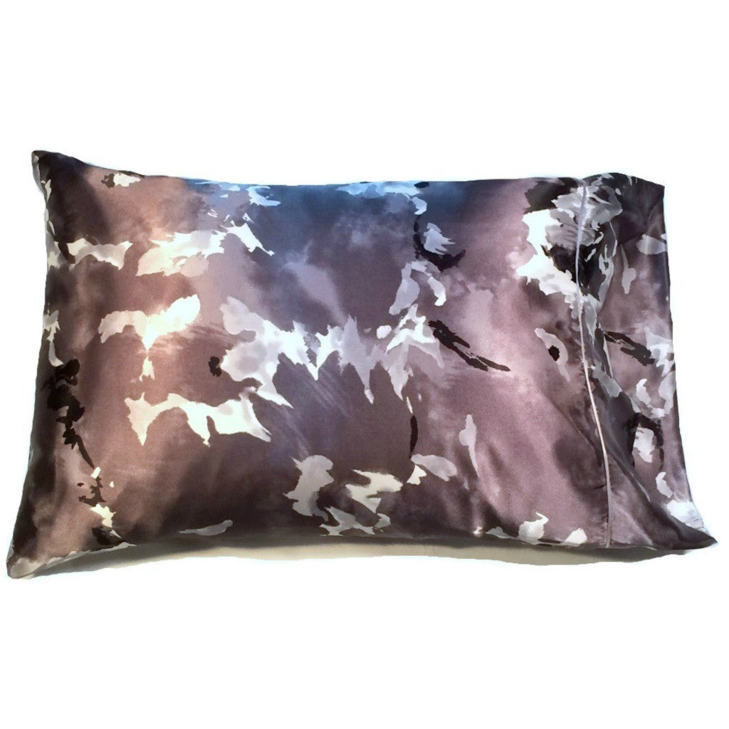 An accent pillow with a white, black, gray and light gray print cover. The cover looks like clouds. The pillow measures 12