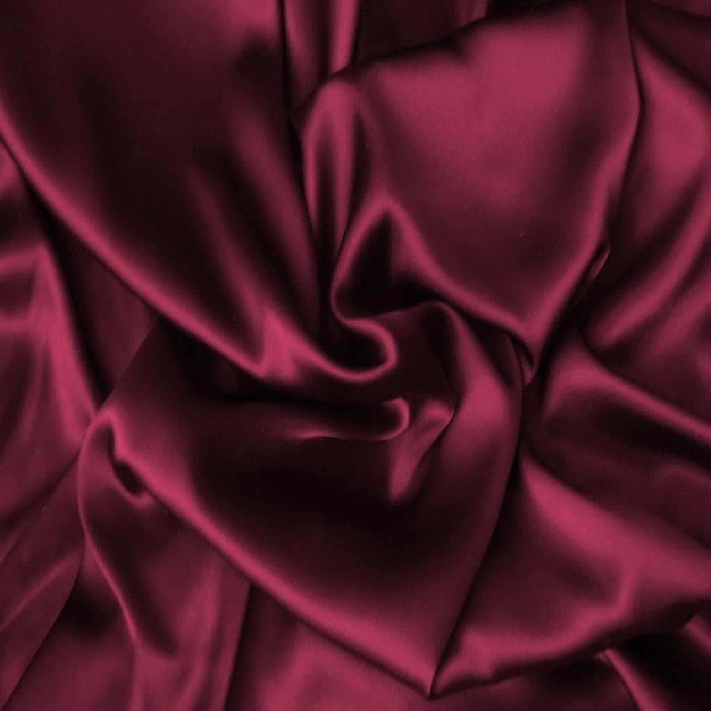 looking at satin material in a solid merlot color. The material is swirled.