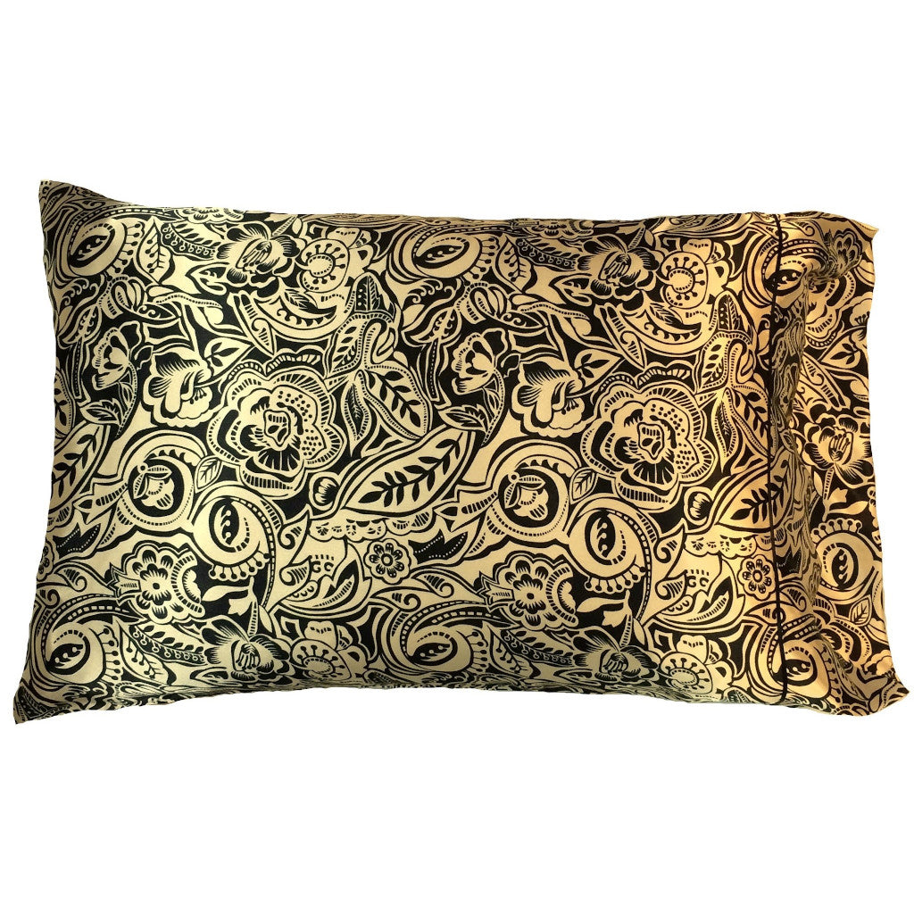 A boudoir pillow with a satin pillowcase in gold with black flowers and leaves. The pillow measures 12