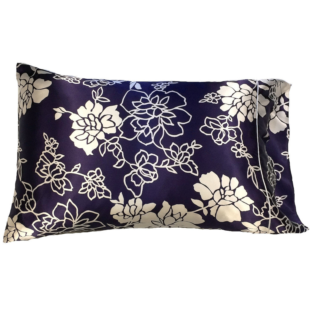 A throw pillow with a navy blue with white flowers and white etched flowers pillowcase. The pillow measures 12