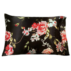 Black satin pillowcase with coral and white colored flowers and green leaves.