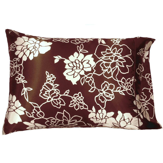 A brown satin pillowcase with white flowers and white etched leaves and etched flowers.