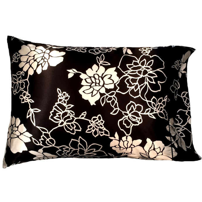A black satin pillowcase with white flowers and white etched flowers.