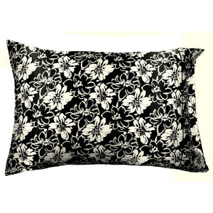 A black satin pillowcase with white flowers and black flowers etched in white.