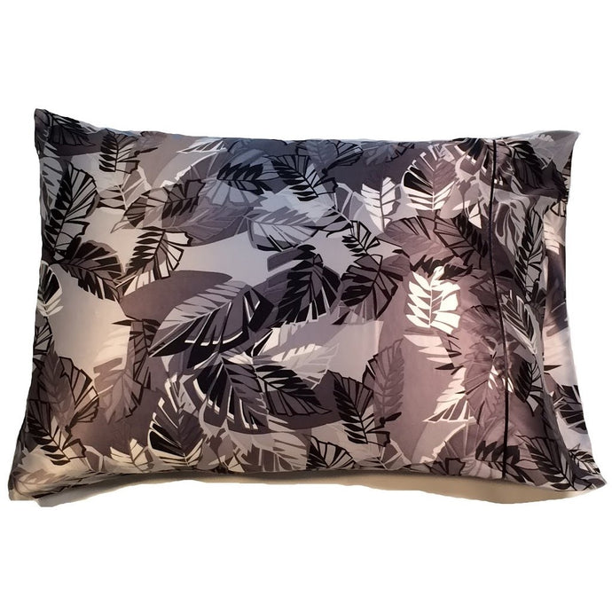 A satin pillowcase with gray, white, silver and black leaves.