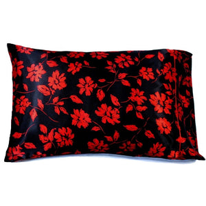 A black satin pillowcase with red flowers and leaves print.
