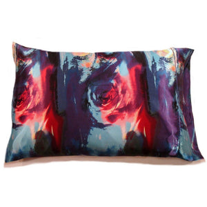 A modern, contemporary print satin pillowcase in a navy blue, red, aqua blue and purple.