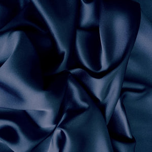 Satin material in a navy blue solid color. The material is swirled.
