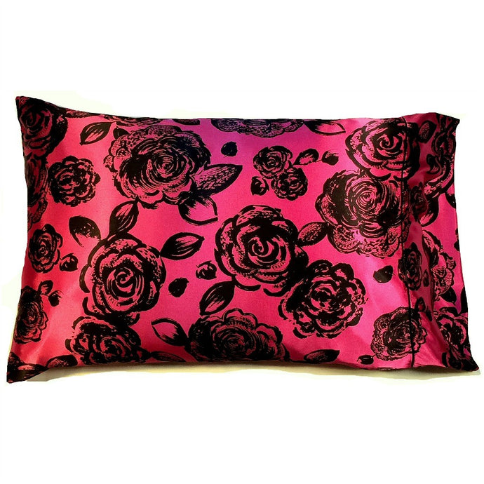 A pink satin pillow case with black rose flowers.