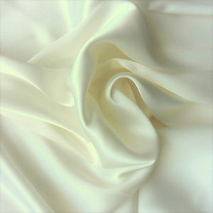A look from above at off white satin material in a swirled pattern.