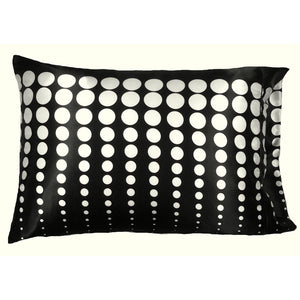 A decorative pillow with a black cover that has white polka dots. The polka dots go vertically and the size of the polka dot goes from small to large. The pillow measures 12" x 16".