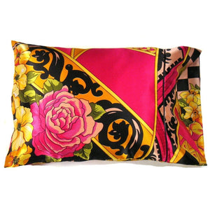 A boudoir pillow with a pillow cover that has a pink rose, yellow flowers and some pink, yellow and black designs. It has a Boho style to it. The pillow is 12" x 16".