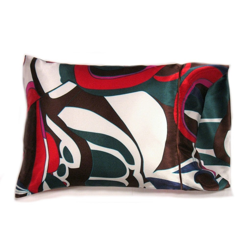 A throw pillow in a red, green, brown and white modern print. The pillow is 12