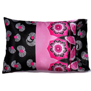 An accent pillow with a back and pink cover. The left side of the pillow is black with white flowers. The right side is in pink with white pink and black flowers. The pillow measures 12" x 16".