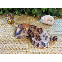 Load image into Gallery viewer, A brown leopard print sleep eye mask. Behind it is a lit candle and a stone with the word&quot; dream&quot; on it. Green plants are in the background.
