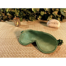 Load image into Gallery viewer, A sage green satin eye shade with an accent candle burning behind it. A stone with the word &quot;dream&quot; is in back of the sleep mask as well.
