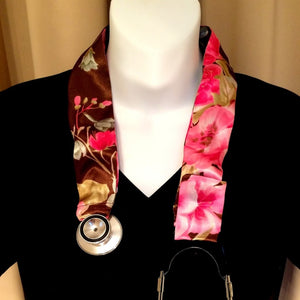 Our med school graduate stethoscope cover is made from a brown with pink flowers charmeuse satin print. The cover is hanging around the neck of a mannequin.