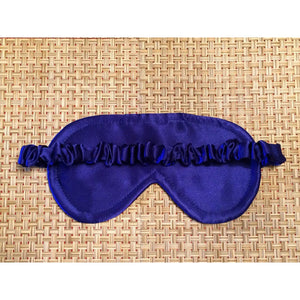 The picture showing the back of a royal blue satin sleep eye mask. The elastic strap is covered in royal blue satin.