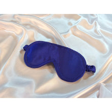 Load image into Gallery viewer, A royal blue satin sleep eye mask is lying on top of white satin sheets.
