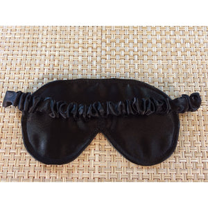 The back view of a black satin eye sleep mask showing the elastic strap that is covered by black satin.