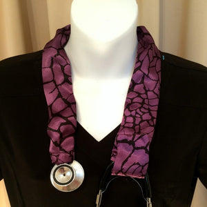 Our stethoscope cover is made from a purple and black charmeuse satin print and is washable. The cover has a Velcro closing to keep it in place.