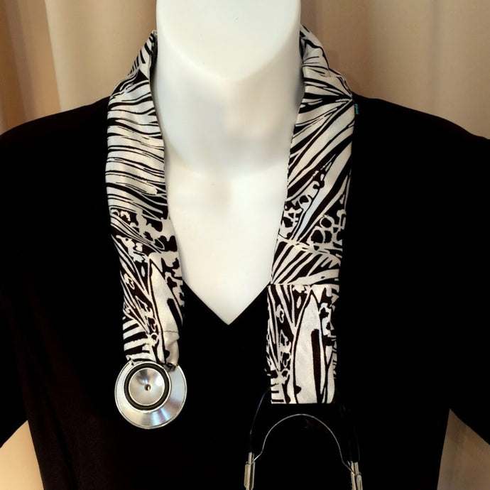 Our stethoscope cover is made from a black and white charmeuse satin print. The cover is hanging around a mannequin.
