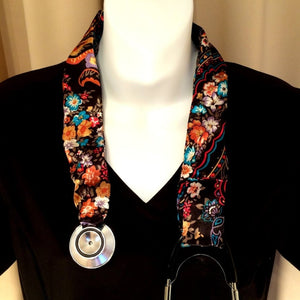 Our stethoscope cover is made from a black, orange and blue charmeuse satin print and is washable. The cover has a Velcro closing to keep it in place.