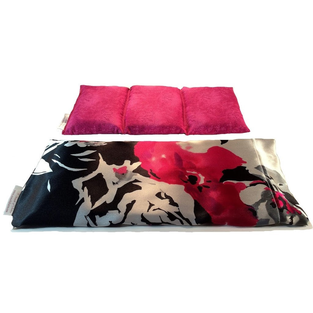 Therapeutic wrap in a black, white and pink print. Behind the wrap is an insert sewn in three  sections. The insert is pink.