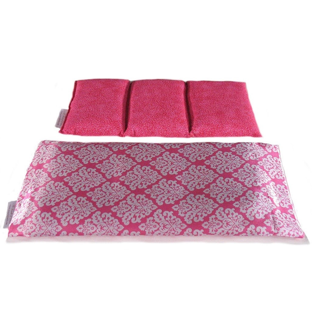 A therapy wrap with a pink and white design satin cover. The cotton insert is sewn into three sections.  The cover of the insert is pink.