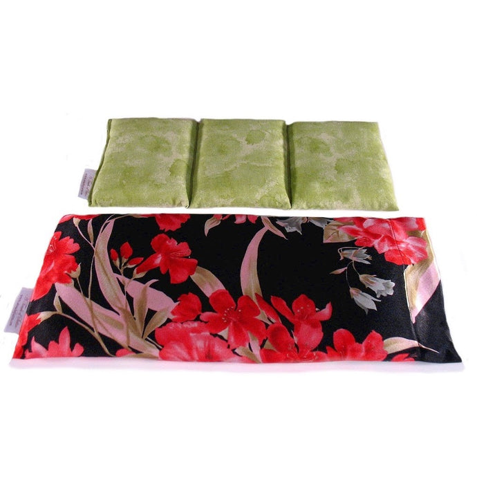 A therapy wrap with a black satin cover. There a red flowers with pink and gree leaves on the cover. Behind the wrap is a cotton insert. The insert is sewn in three sections. The cover of the insert is a muted green design.